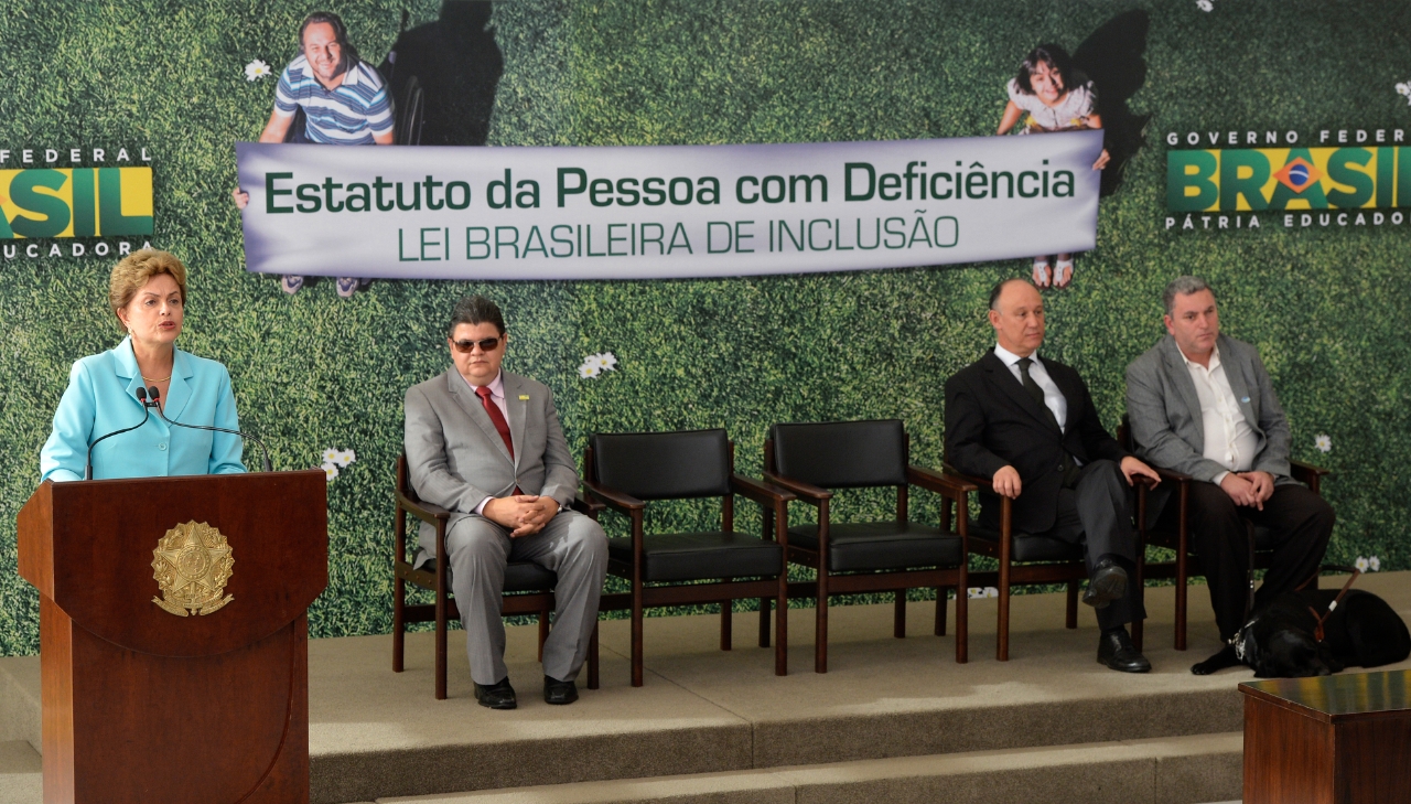 Mulher discursando em evento sobre o Estatuto da Pessoa com Deficiência. Mais na postagem